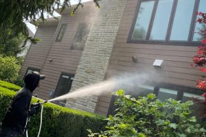 Man power washing from a lift Oh paneless